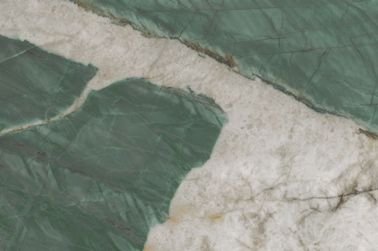 Close-up of a stone surface with green and white marbled patterns, featuring distinct veins and irregular color transitions, creating an abstract, natural texture.